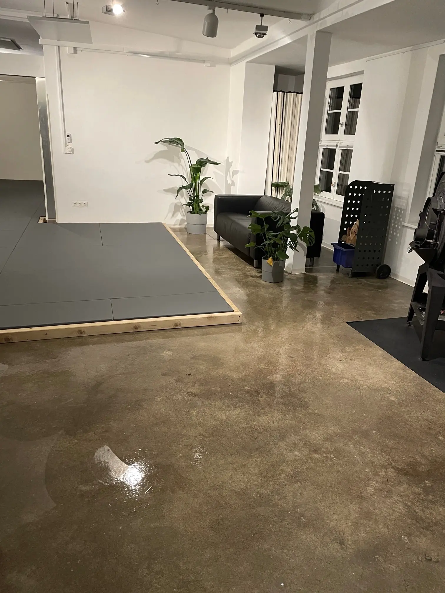 Frisch gewischter Betonboden in der Sporthalle von Evolve Grappling Solingen, links die Trainingsmatten